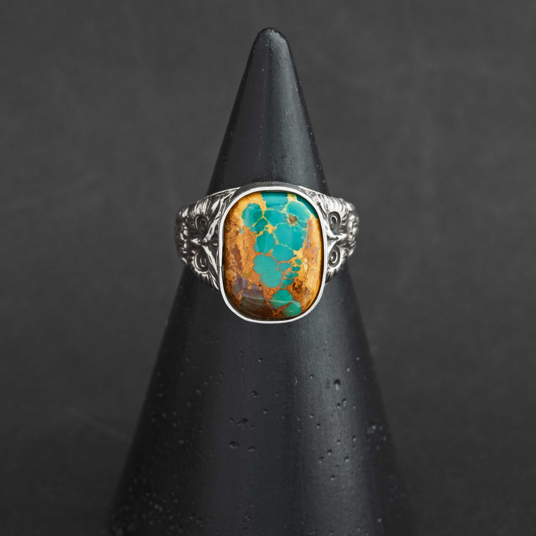 Front view of handmade Royston Ribbon turquoise owl ring in sterling silver, showing golden-brown matrix with turquoise veining and ornate silver band.