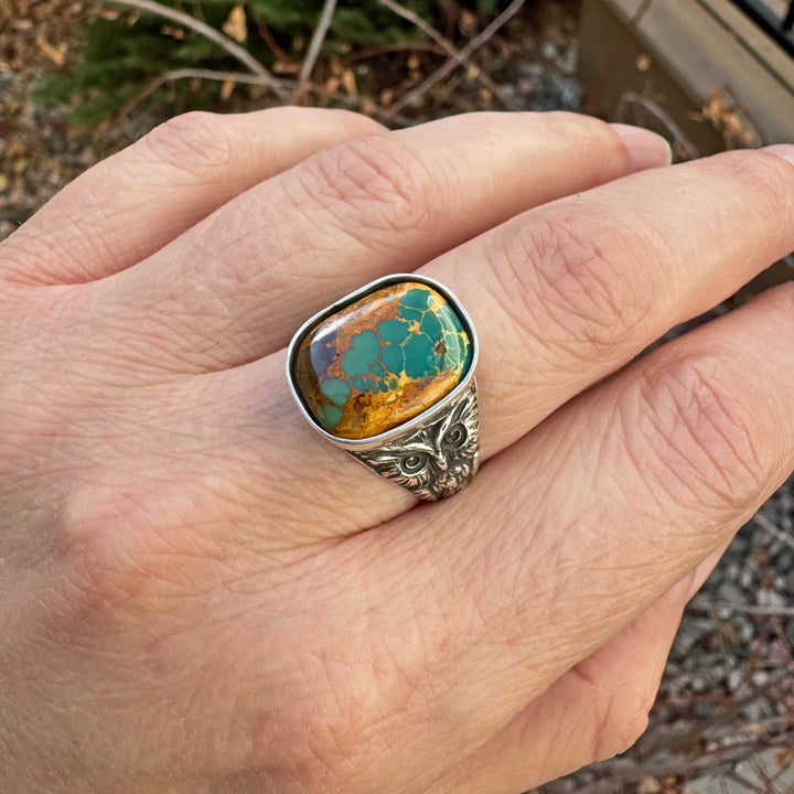 Royston Ribbon turquoise owl ring in sterling silver shown worn on hand, with vivid turquoise ribbons running through warm desert-brown host rock.