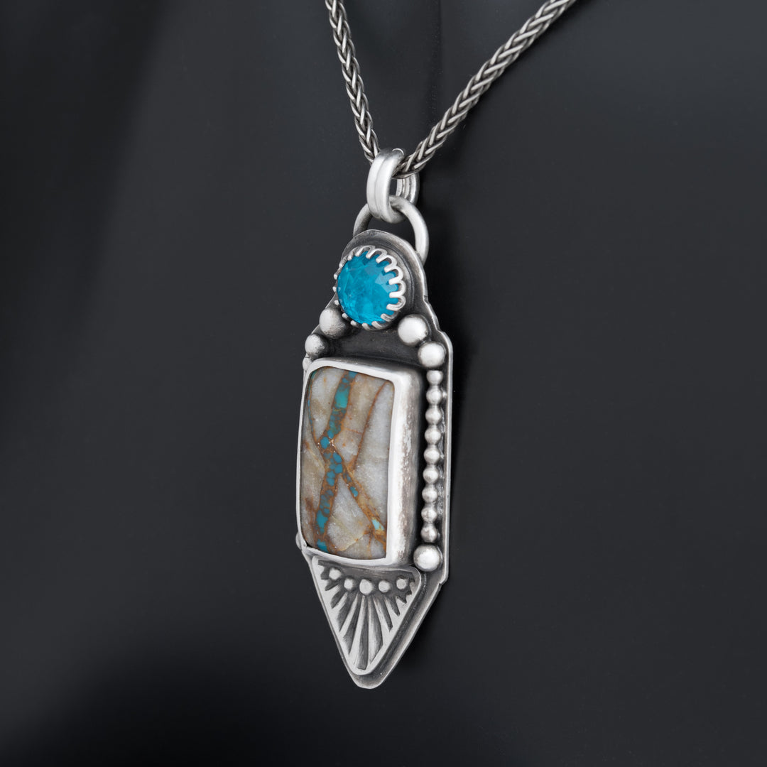 Angled view of sterling silver Royston Ribbon turquoise pendant with faceted neon apatite and stamped detailing.