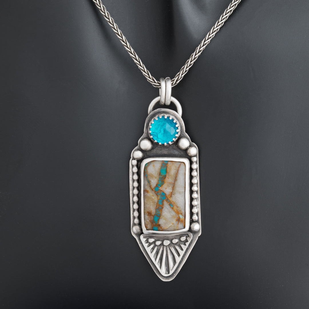 A sterling silver pendant featuring a square-cut Royston Ribbon turquoise with neon apatite, with a hand-stamped design and a sterling silver chain.