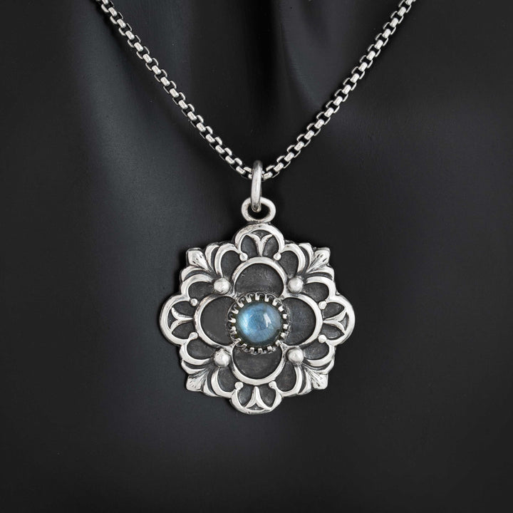 Handcrafted sterling silver flower pendant with iridescent blue flash labradorite cabochon