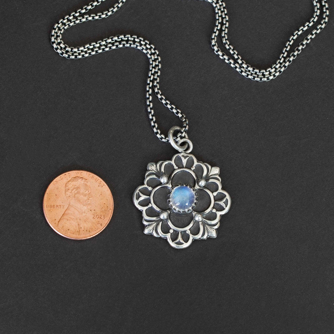 Handmade sterling silver pendant with vibrant blue flash moonstone and quatrefoil pattern