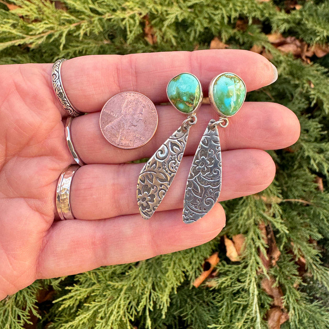 Size reference of sterling silver Sonoran Gold turquoise western floral dangle earrings next to a US penny