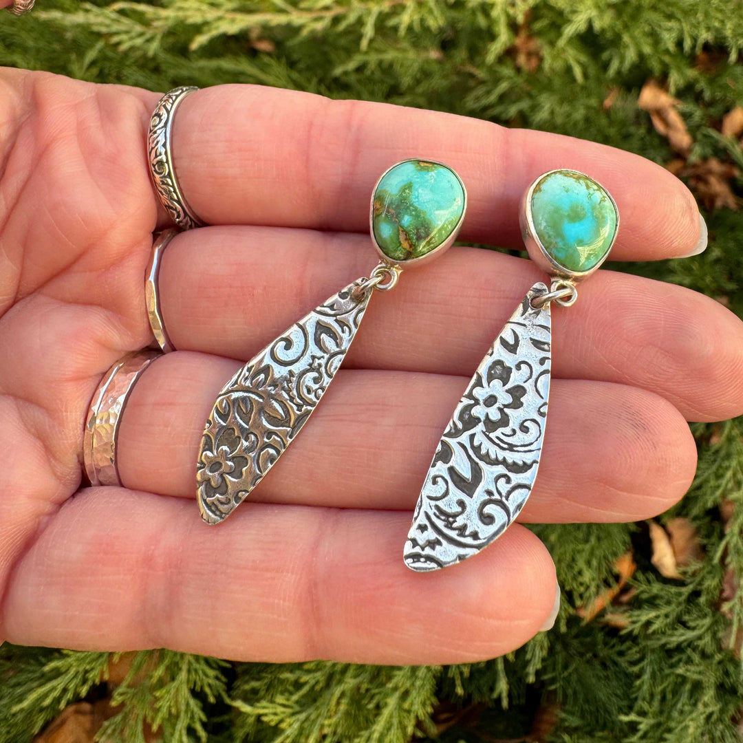 Close-up of Sonoran Gold turquoise set in sterling silver with western floral engraved dangle design