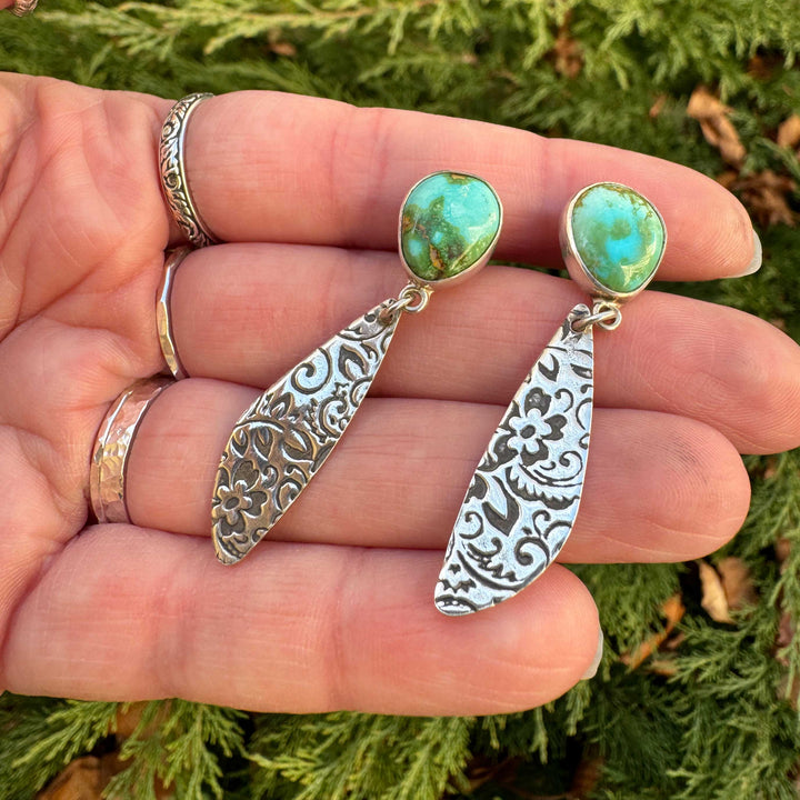 Close-up of Sonoran Gold turquoise set in sterling silver with western floral engraved dangle design