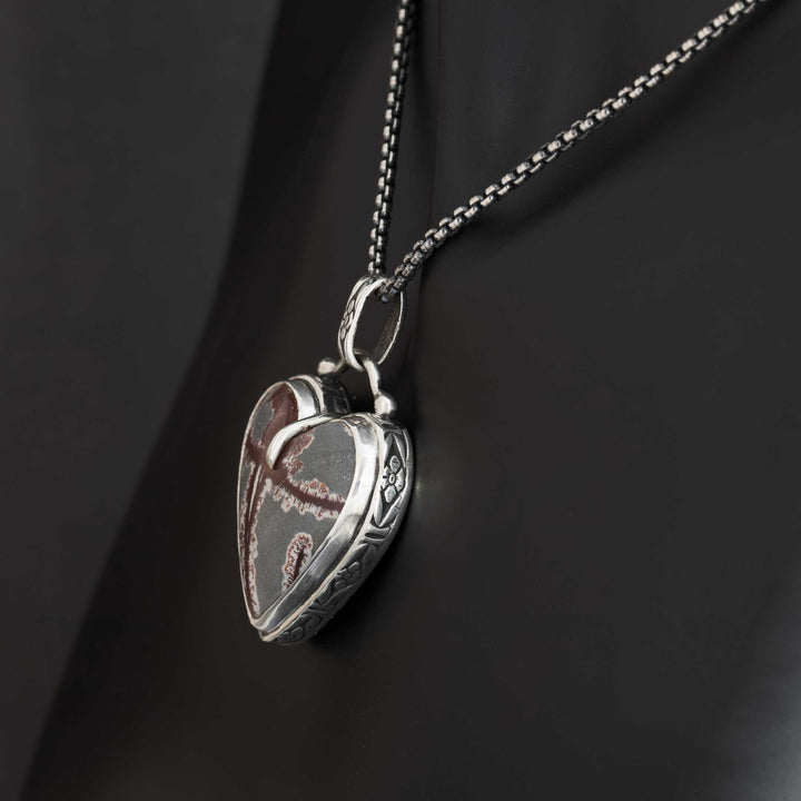 Side view of sterling silver heart pendant with dendritic rhyolite