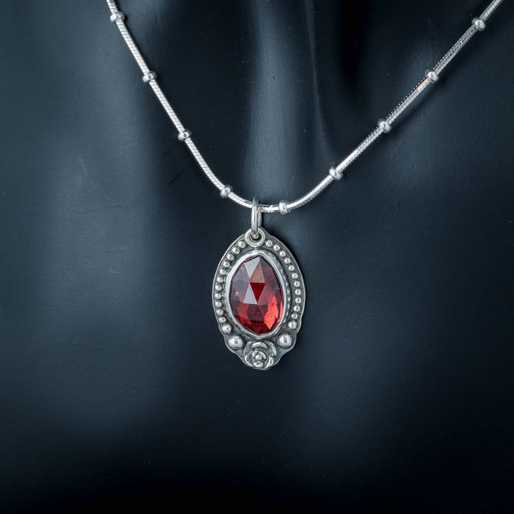 Unique pendant necklace with a red garnet rose design.