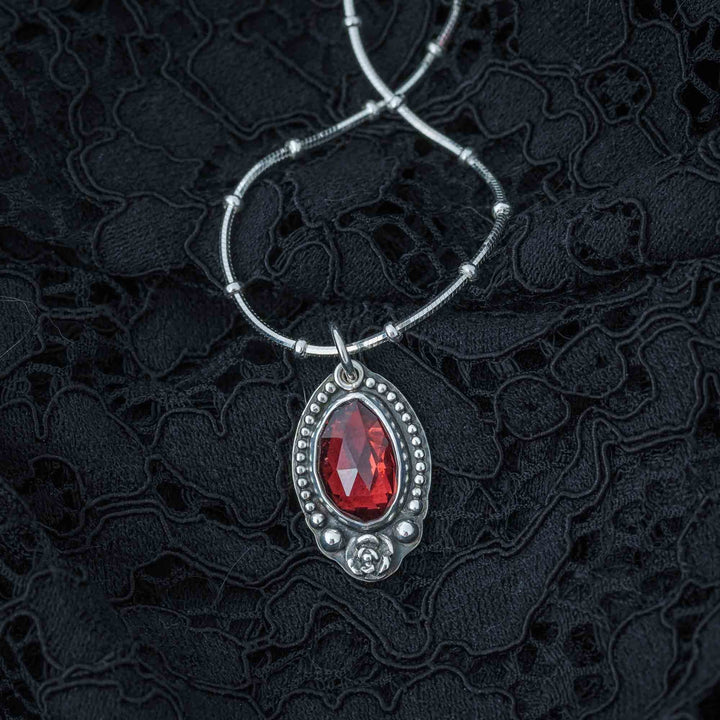 Handcrafted gothic necklace with a red garnet rose in sterling silver.