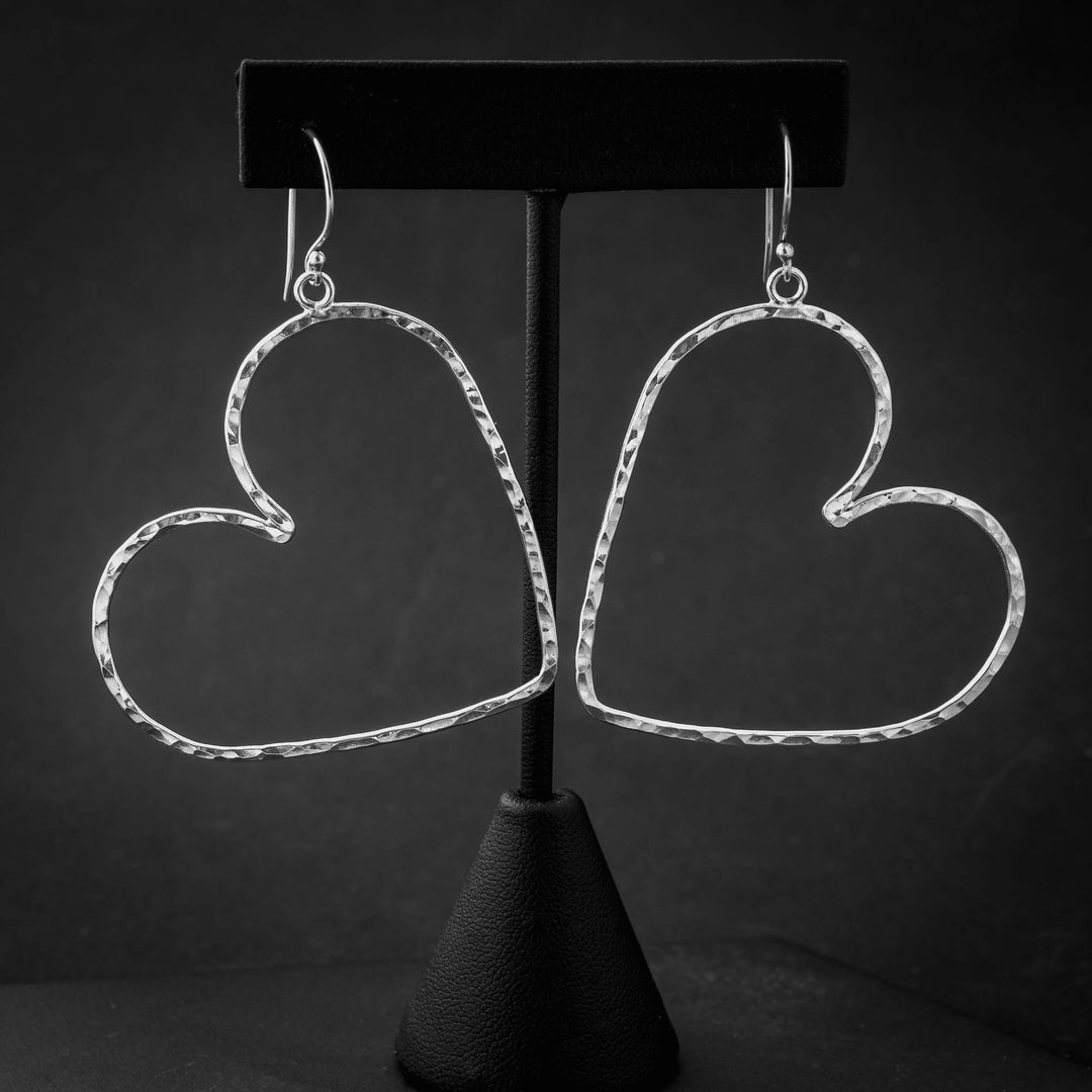 Handmade sterling silver heart hoop earrings with hammered texture and open heart design