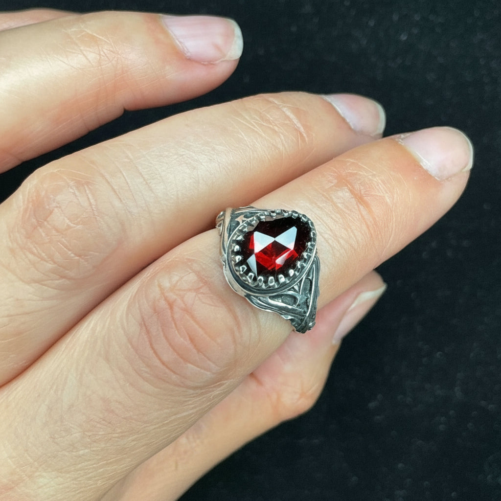 Elven inspired sterling silver garnet ring with detailed scrollwork and oxidized handcrafted finish.