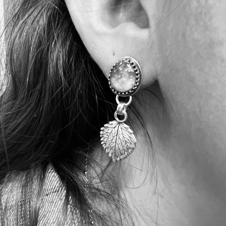 Sterling silver Sonoran Gold turquoise aspen leaf earrings shown worn on ear.