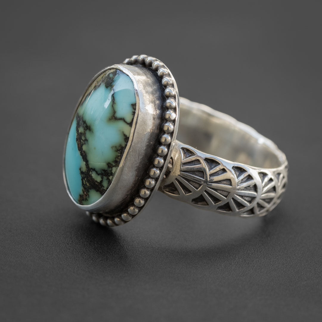 The side view of a silver turquoise stone ring in size 7. Hand fabricated in Fort Collins, Colorado.