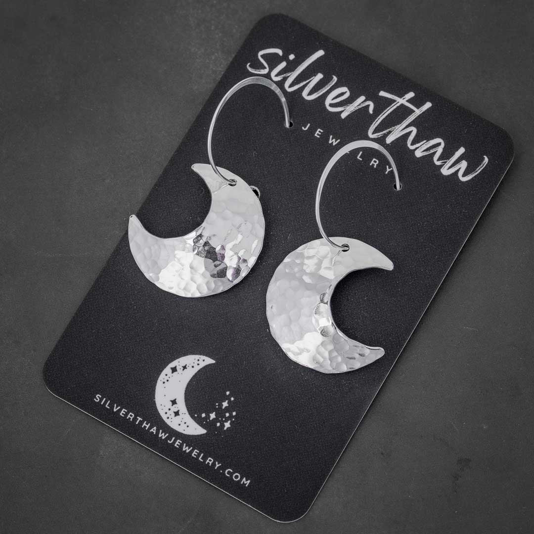 Handmade wicca earrings displayed on a Silverthaw Jewelry earring card. The moon hoops are sterling silver crescent moons that have been hammer textured and highly polished. Fabricated in Fort Collins, CO. 