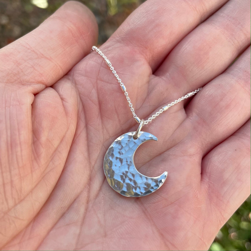 A silver moon pendant necklace handmade in Colorado.